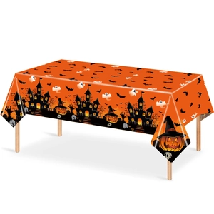 Detail of Halloween tablecloth featuring pumpkin lanterns, ghosts, and bats on orange fabric