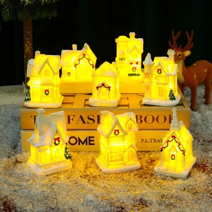 Detailed view of warm LED glowing resin Christmas village houses with snowy glitter finish