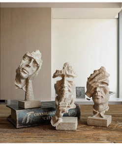 Close-up of Nordic abstract thinker statues with textured sandstone finish on vintage books