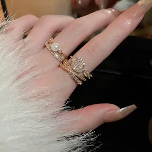 Set di anelli placcati in oro con perla e zircone su mano con polsino in pelliccia