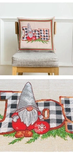 Close-up of JOY embroidery and linen texture on Christmas Santa pillow cover on chair