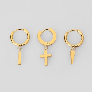 Detailaufnahme goldener Creolen mit Kreuz-, Stab- und Dornanhängern aus Edelstahl