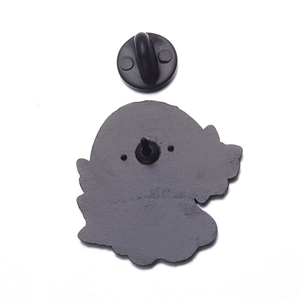 Detail of the black rubber butterfly clutch and metal pin backing on a cartoon badge