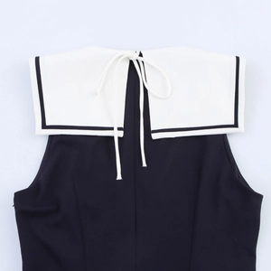Detail of sailor collar with white bow tie on back of black sleeveless pleated dress