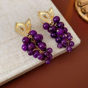 Detailed close-up of French vintage grape earrings with purple beads and crystal gold leaves