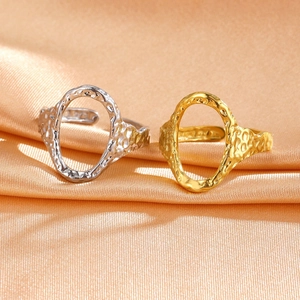 Detailed macro view of gold and silver irregular hammered open rings on silk fabric