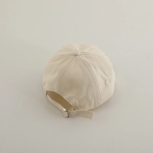 Rear view of cream toddler baseball cap featuring adjustable silver metal buckle and strap