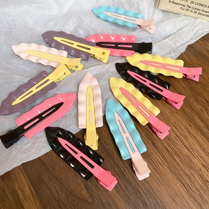 Minimalist macaron wave hair pins in various colors on a stylish wooden background