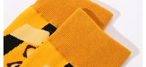 Macro shot of yellow cotton crew socks with abstract geometric patterns and ribbed cuff