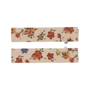 Detail of two beige fabric-wrapped BB clips with floral embroidery for kids