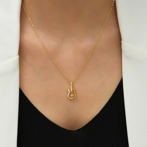 Minimalist gold guitar necklace with micro-paved cubic zirconia worn on a model