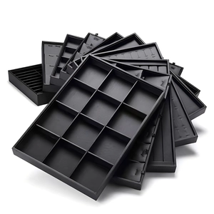 Black PU leather jewelry display trays for rings and watches on white background