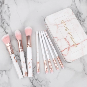 Close-up of 8-piece marble makeup brush set with rose gold ferrules in a portable tin box