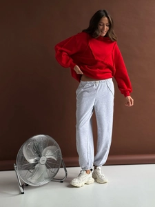 Y2K oversized red hoodie with grey joggers and white sneakers on a female model
