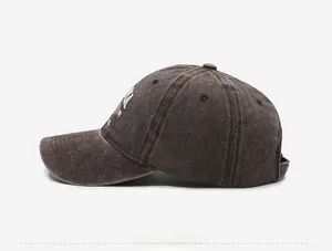 Side view of brown washed vintage baseball cap with white embroidery details