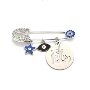 Detail of silver safety pin brooch with Evil Eye charms and Arabic calligraphy disc