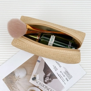 Minimalist beige woven makeup bag with portable handle and professional storage design