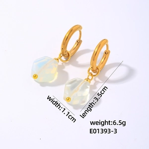 Detail of geometric gold ring earrings with translucent natural white stone pendants
