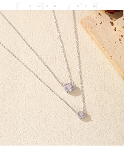 Detail of layered S925 silver necklaces with lavender round-cut crystal pendants