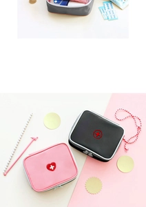 Detail view of pink and black portable medical kits with heart embroidery and zippers