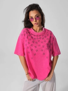 Close-up of pink oversized cotton T-shirt featuring rhinestone H letter patterns