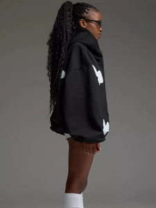 Side view detail of a loose black hoodie with white floral print and a thick knitted texture