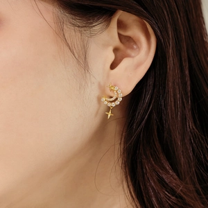 Élégantes boucles d'oreilles lune et étoile en argent S925 doré portées par un modèle