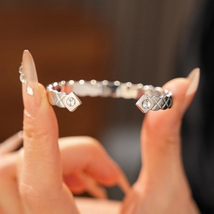 Détails macro du bracelet ouvert argenté à motif matelassé et pierres en zircon