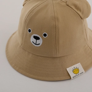 Détail chapeau de soleil bébé kaki clair avec oreilles d'ours et broderie visage ours