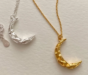 Macro shot of S925 sterling silver moon pendants with textured lava surface in gold and silver