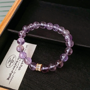 Close-up of purple amethyst beads and gold zircon spacer in a black jewelry box