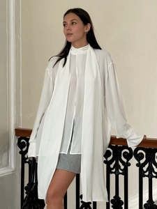 Elegant white chiffon long sleeve shirt with high neck necktie on a classic staircase