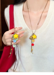 Detail of colorful acrylic star pendants and vintage square charm on long cord necklace