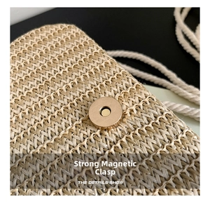 Gros plan sur le fermoir magnétique et la texture tressée du sac à main en paille