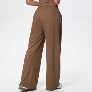 Detail of loose brown wide leg pants showing elastic waist and smooth draped fabric