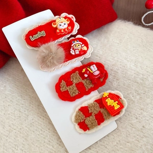 Vue détaillée du lot de 4 barrettes du Nouvel An avec breloques en peluche rouge et métal
