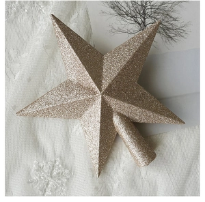 Close-up of golden glitter star tree topper with conical base on aesthetic background