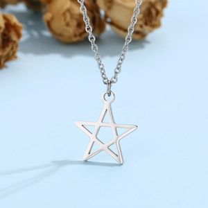 Detail shot of a silver stainless steel hollow star pendant on a delicate metal chain