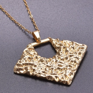 Detailed view of textured 18k gold plated irregular square hollow pendant on chain