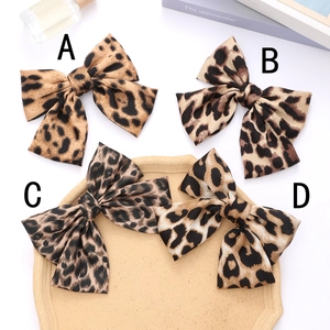 Chic leopard print bow hair clips in four styles on a decorative display tray