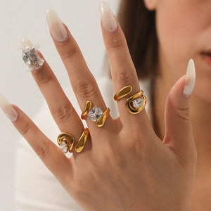 Detail of adjustable gold ring featuring sparkling zircon stones on a model's finger