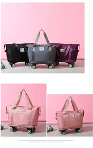 Detailed view of foldable travel bags in pink, grey, and black with smooth swivel wheels