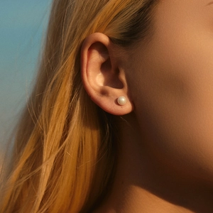 Classic S925 sterling silver pearl stud earrings shown on model with white luster
