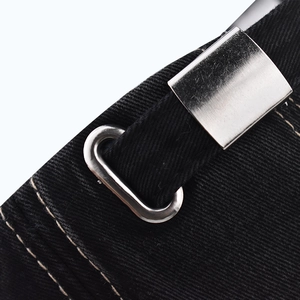 Macro detail of the adjustable metal buckle and stitching on a black denim baseball cap