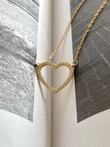 Detailed view of a gold heart pendant necklace with shimmering zircon pavé setting