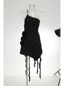 Detail of one-shoulder black dress with 3D rose accents and irregular ruffled hem