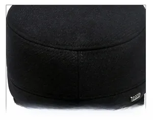 Macro detail of the twill wool fabric and stitched seams on a men's winter flat top cap