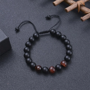 Detail of adjustable tiger eye and black lava stone beaded bracelet with woven cord
