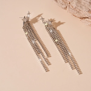 Macro shot of silver zircon star earrings with diamond tassels and sparkling starburst effects