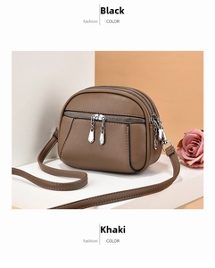 Detail view of khaki PU leather crossbody bag featuring triple zipper compartments